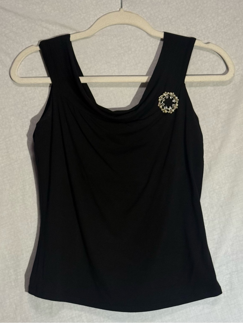 Classic Chic Black Sleeveless Top with Elegant Broach